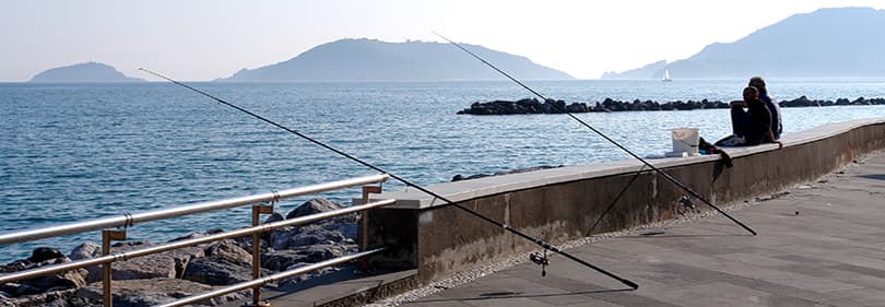 Die Menschen angeln in Ligurien am Abend